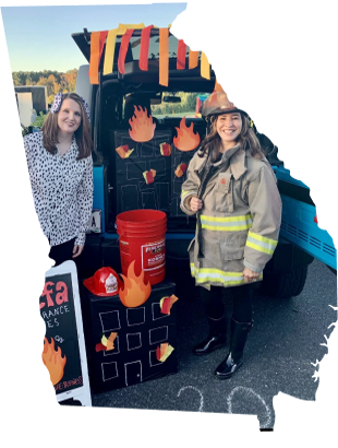 Georgia outline with ladies by a decorated tailgate promoting fire safety